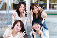 女性4名が笑顔でピースサインして写っている写真